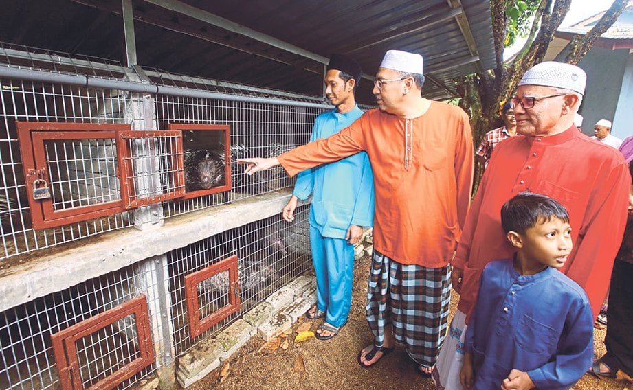TIMBALAN Menteri Komunikasi dan Multimedia Datuk Seri Jailani Johari (dua dari kanan) melawat ternakan landak milik Mohammad Fauzan.