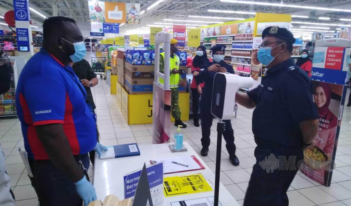 RAMLI (kanan) bertanya sesuatu kepada pengurus sebuah pasar raya sempena lawatan pemantauan pematuhan Perintah Kawalan Pergerakan Bersyarat (PKPB) di daerah Kuala Selangor. FOTO Amirul Aiman Hamsuddin