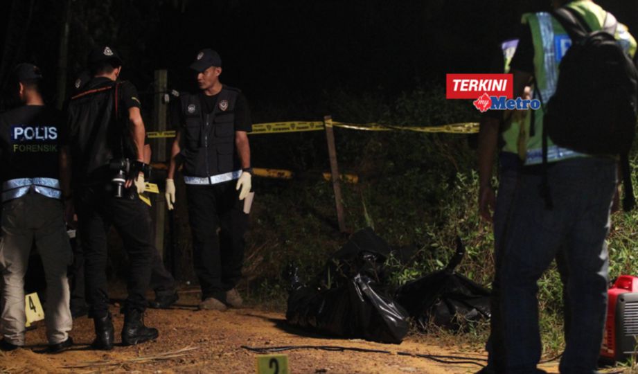 ANGGOTA Forensik memerika dua mayat penjenayah yang ditembak mati di ladang kelapa sawit berhampiran Felcra Sungai Ara, Kota Tinggi. FOTO Mohd Azren Jamaludin 
