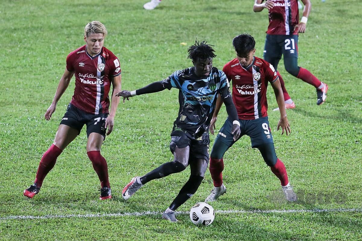 PEMAIN Terengganu FC II, Jordan Mintah (tengah) diasak pemain Kelantan United, Yuki Tanigawa (kiri). FOTO Ghazali Kori