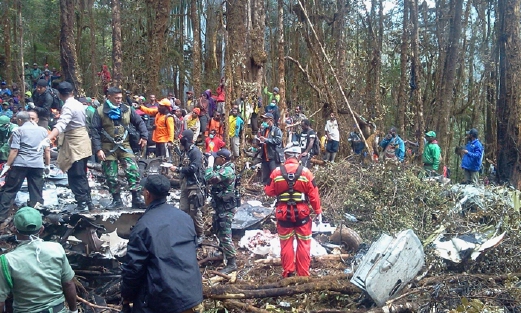 Anggota penyelamat menggeledah serpihan pesawat ATR 42-300 bagi mencari kemungkinan ada anggota badan mangsa. - Foto  AFP 