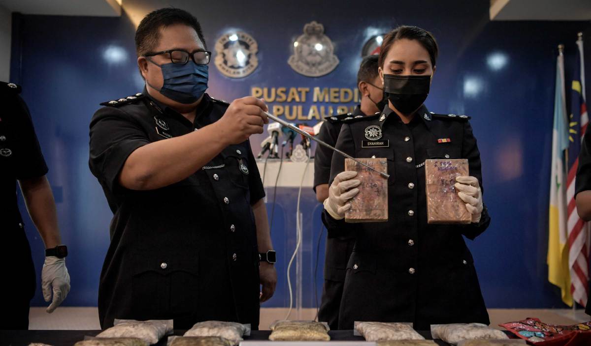 MUSTAFA Kamal Gani (kiri) menunjukkan dadah jenis heroin base, heroin dan syabu yang dirampas bernilai RM134,800 dalam tiga serbuan di kawasan Seberang Perai Tengah pada sidang media di IPK Pulau Pinang. FOTO BERNAMA