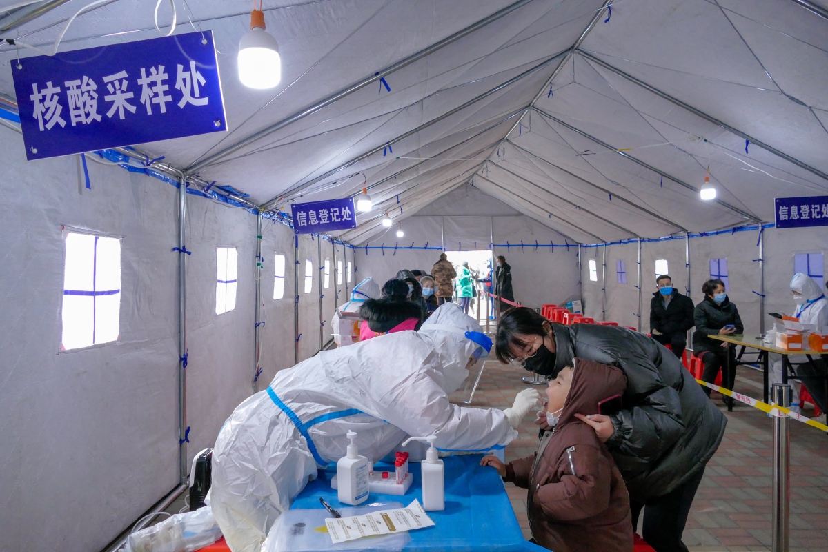PEKERJA kesihatan mengambil sampel daripada individu ketika ujian saringan Covid-19 di Tianjin. FOTO EPA 