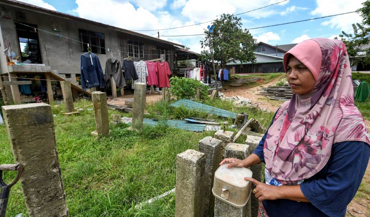 CHE Hasniza melihat tiang rumahnya, yang masih tinggal apabila rumahnya musnah dihanyutkan banjir pada 1 Mac lepas di Kampung Tersang, Rantau Panjang. FOTO BERNAMA