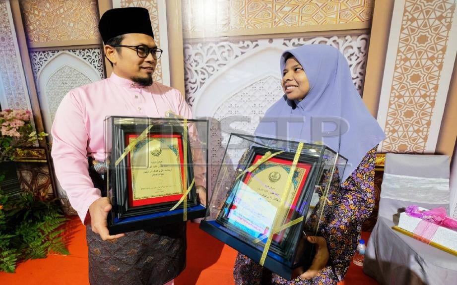 Mohd Kamaruzaman dan Nor Hazira pada Majlis Penutup dan Penyampaian Hadiah Tilawah dan Menghafaz al-Quran Peringkat Negeri Perak. FOTO BERNAMA    