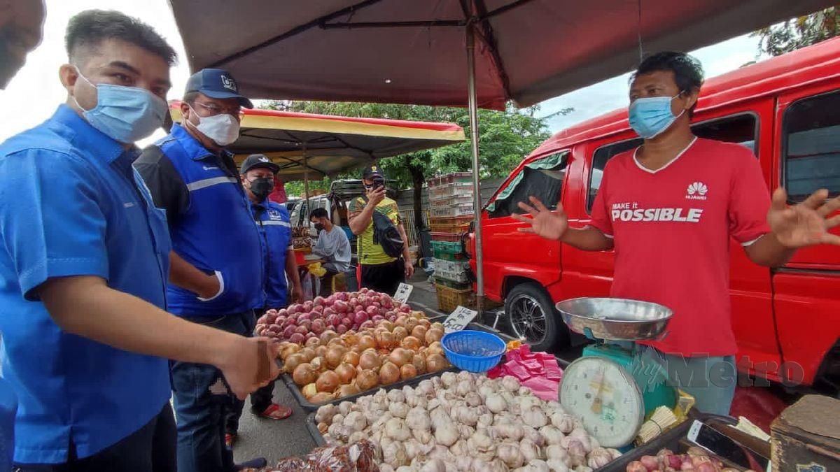 Mohamad Yusrizal (kiri) bersama Pemuda UMNO Alor Setar ketika meninjau harga bawang di Pasar Kampung Berjaya di sini, hari ini. Foto Noorazura Abdul Rahman
