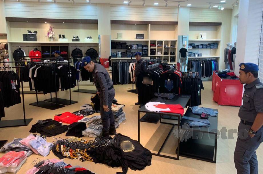 Pegawai KPDNHEP melakukan pemeriksaan dan rampasan terhadap sebuah butik mewah di Bangsar, Kuala Lumpur yang menjual pakaian cetak rompak semalam. FOTO ihsan KPDNHEP
