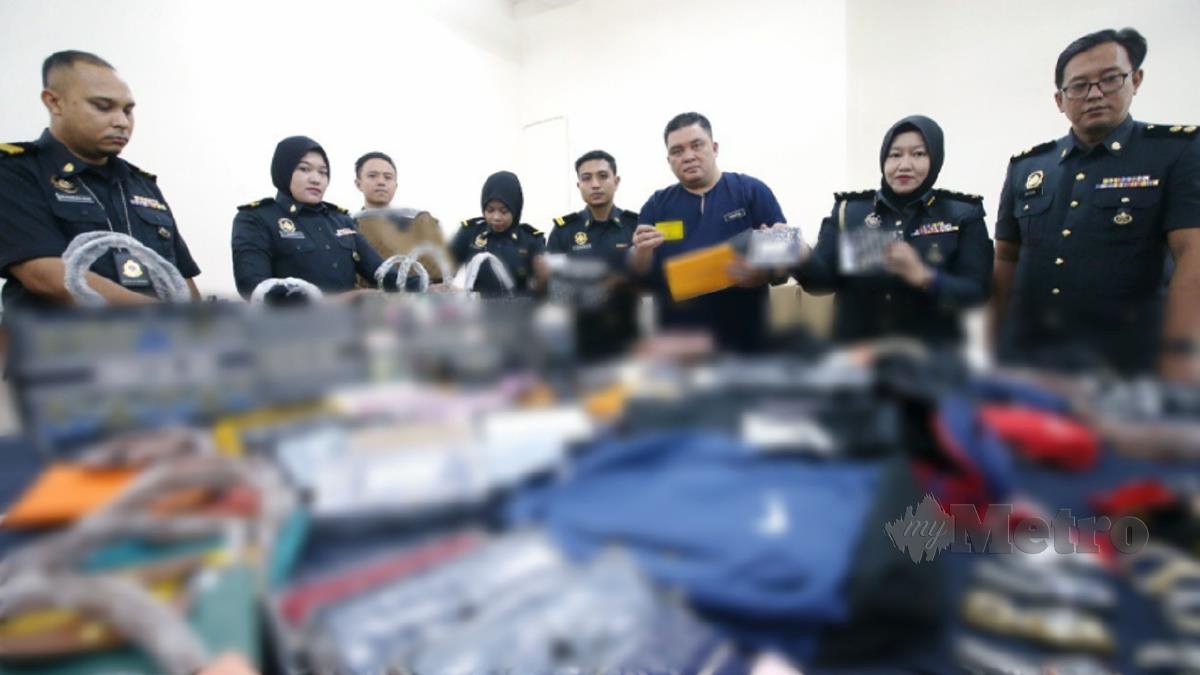 ARIFFIN bersama pegawai dan anggotanya menunjukkan sebahagian barangan yang dirampas. FOTO Eizairi Shamsudin