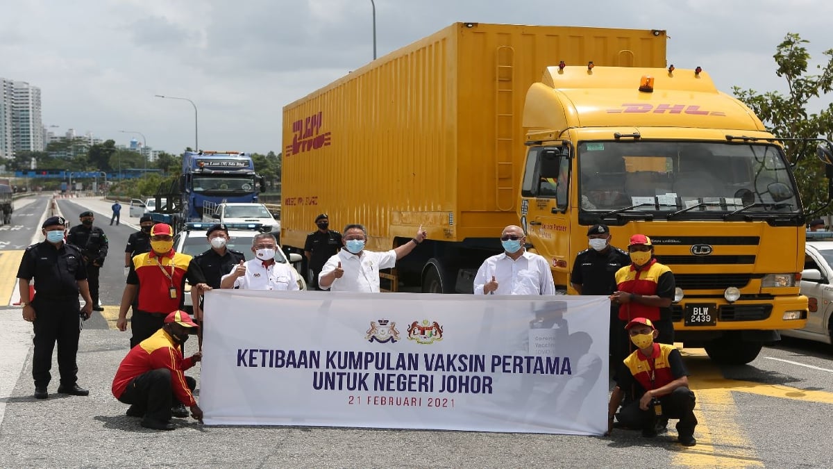 DATUK Hasni Mohammad (tengah) bersama Datuk Seri Dr Adham Baba menyambut ketibaan kumpulan vaksin pertama negeri Johor di tengah sempadan dua negara di Tambak Johor, hari ini. FOTO PEJABAT MENTERI BESAR