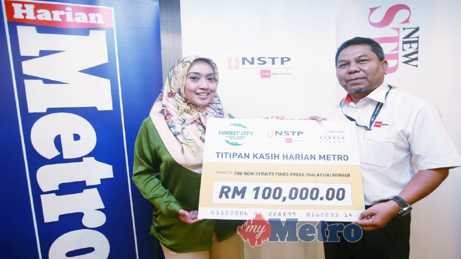 OTHMAN (kanan) menerima replika cek daripada Aeron untuk program amal Titipan Kasih Harian Metro (TKHM) di Balai Berita Kuala Lumpur, semalam. FOTO Sairien Nafis