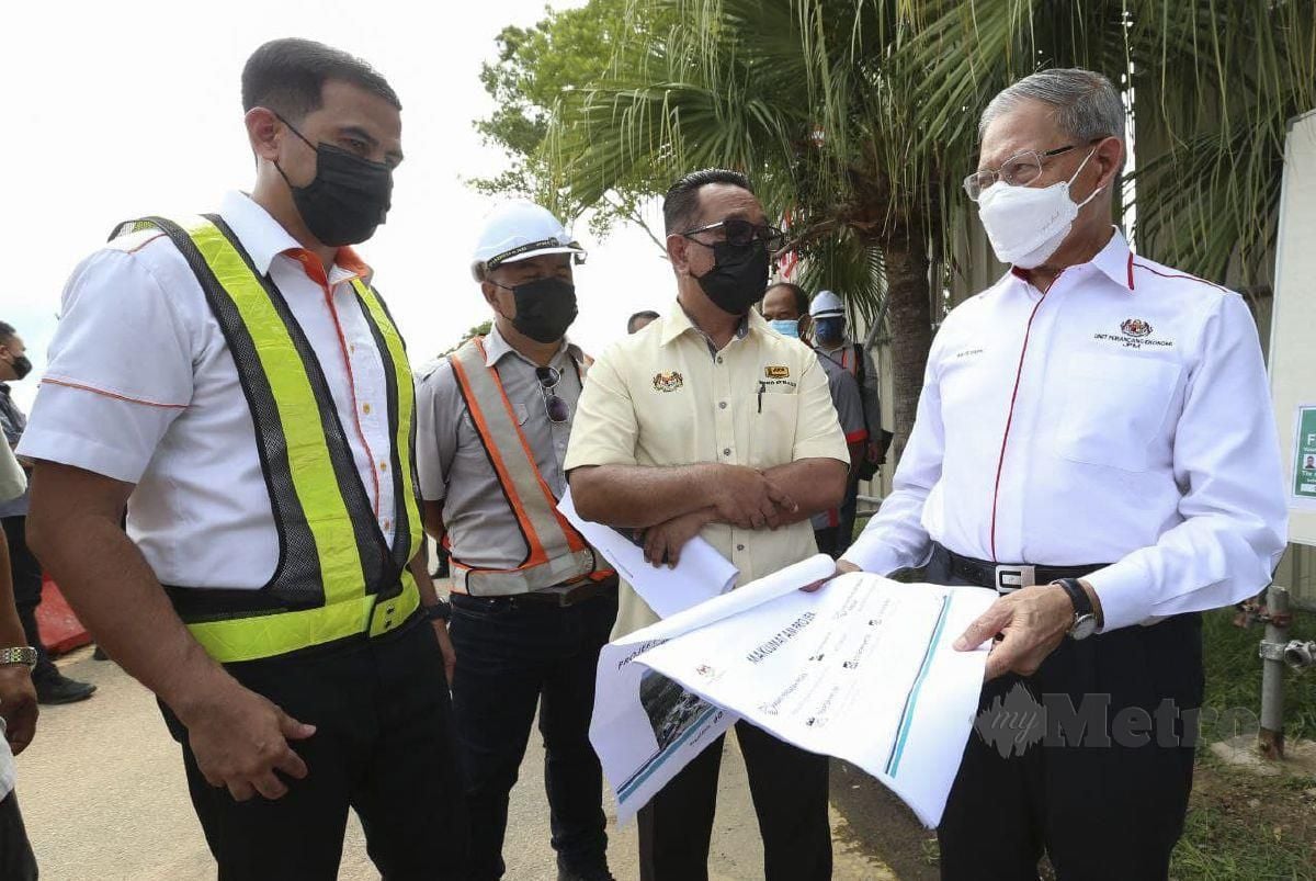 Mustapa (tengah) melihat kertas cadangan baikpulih Projek Pembesaran dan menaik taraf Lapangan Terbang Sultan Ismail Petra (LTSIP) Kota Bharu di sini, hari ini. FOTO NIK ABDULLAH NIK OMAR