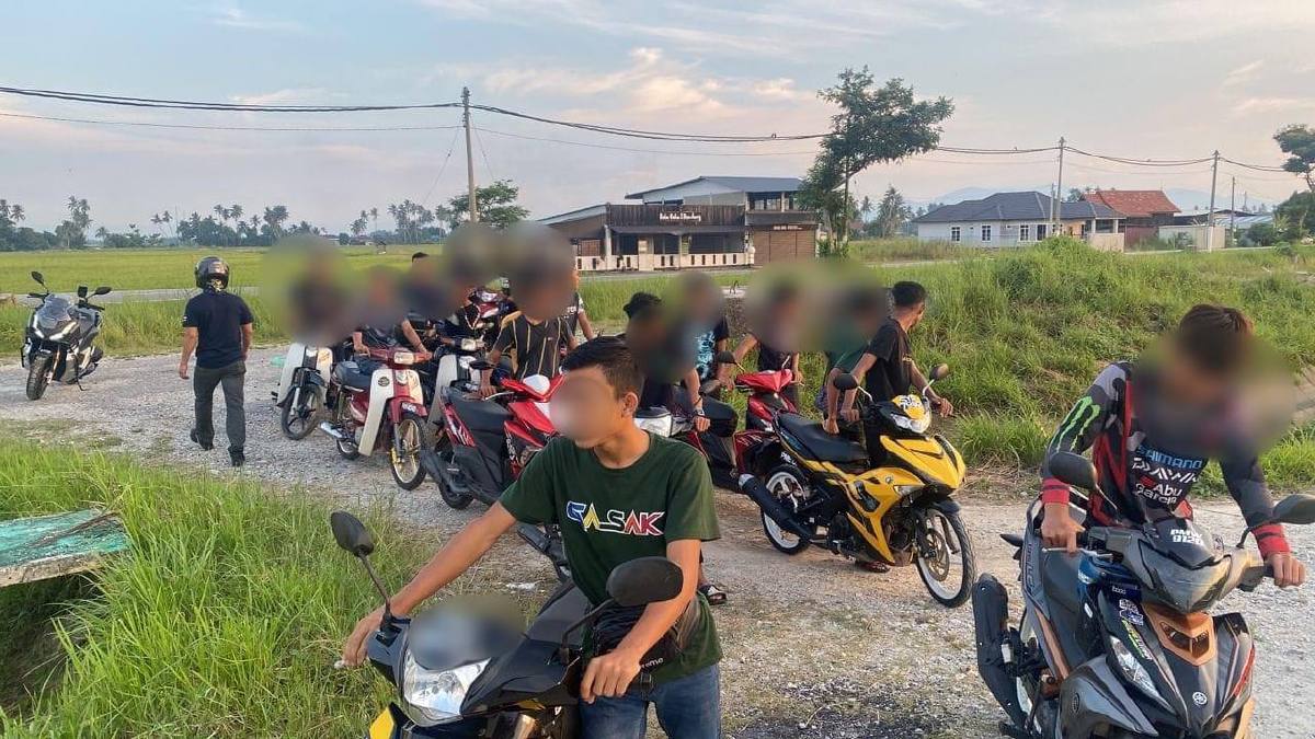 SEKUMPULAN remaja diarahkan menolak motosikal selepas merempit di Jalan Lahar Kepar, Kepala Batas. FOTO Ihsan PDRM.