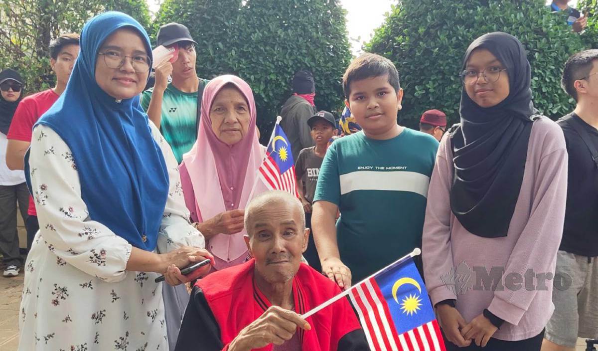 HALINA (kiri) membawa ibu bapa dan anaknya menyaksikan perbarisan Hari Kemerdekaan di Dataran Putrajaya. FOTO Samadi Ahmad