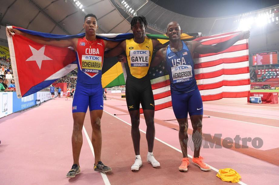 Dari kiri - Echevarria, Gayle (pingat emas) dan Henderson bergambar selepas menyertai acara lompat jauh. FOTO AFP