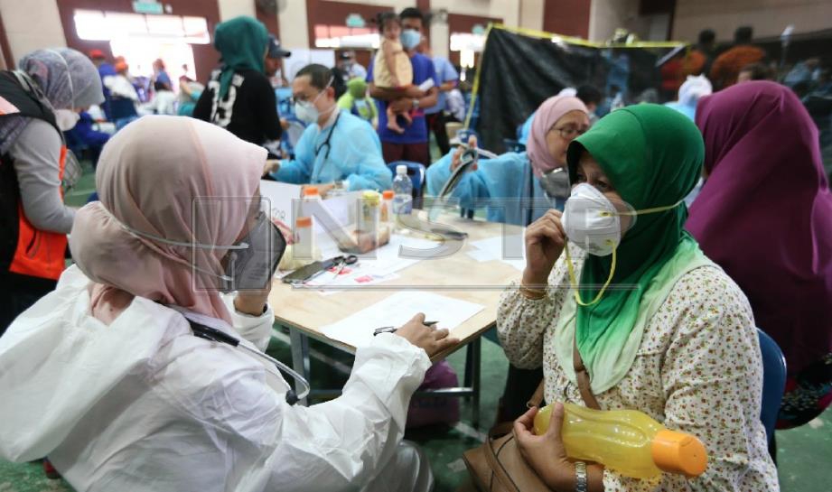 ORANG ramai memakai pelbagai jenis topeng ketika mendapat rawatan di Dewan Komuniti Taman Pasir Putih, Pasir Gudang selepas dipercayai terhidu gas kimia berbahaya. FOTO Mohd Azren Jamaludin.