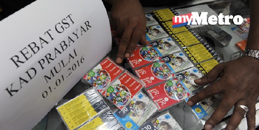 Penjual alat telekomunikasi, Abdul Jaber Ibrahim Shah, 43, menyusun kad prabayar serta mempamerkan notis pemberitahuan rebat GST di kedainya di Jalan Dato Keramat, Pulau Pinang, hari ini.   - Foto BERNAMA 