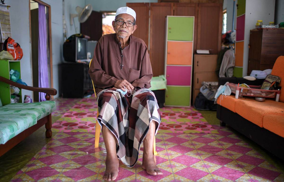 SHAARI yang mengalami kesukaran untuk keluar dari kampung dan tidak mampu berdiri lama akibat gout yang menyebabkan kedua kakinya sentiasa membengkak menjadi penghalang untuk ke Pusat Pemberian Vaksin (PPV). FOTO BERNAMA
