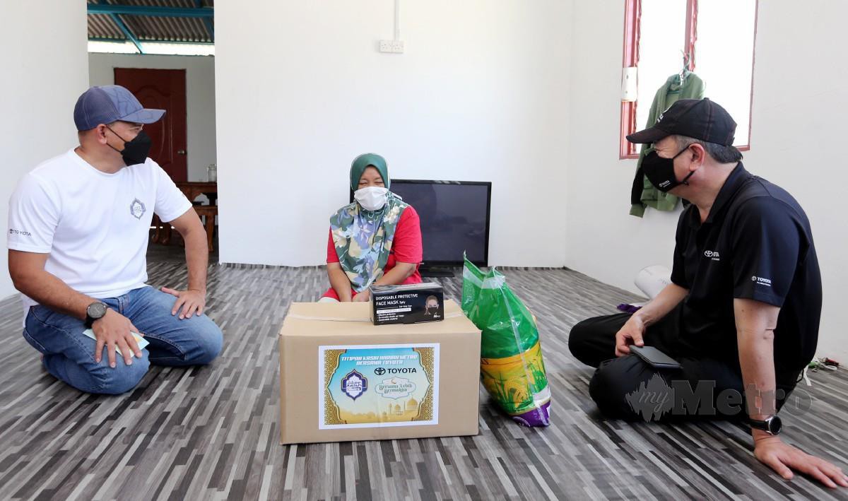 Husain (kiri) dan Mohd Shamsor (kanan) menyampaikan sumbangan kotak rezeki kepada asnaf pada program Titipan Kasih Harian Metro Bersama Toyota, FOTO SAIFULLIZAN TAMADI.