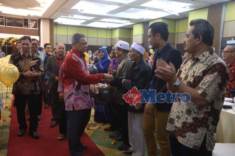 Mustapa diiringi Said (kiri) bersalaman dengan hadirin di Majlis Apresiasi Pengurusan Pemulihan Dalam Komuniti (PDK) Negeri Kelantan di Pusat Dagangan Kelantan (KTC), Kota Bharu. FOTO ZAMAN HURI ISA