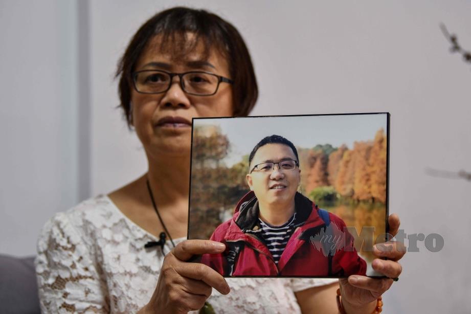 Zhong Hanneng menunjukkan gambar anaknya yang maut akibat Covid-19. FOTO AFP 