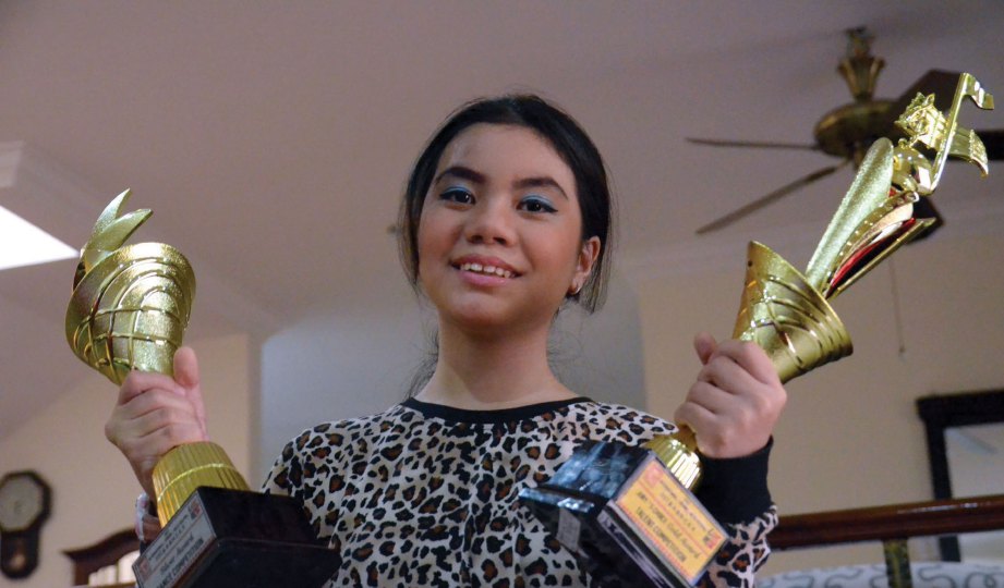 SHARIFAH Nur Syafina bersama piala yang dimenangi dalam pertandingan peringkat antarabangsa.