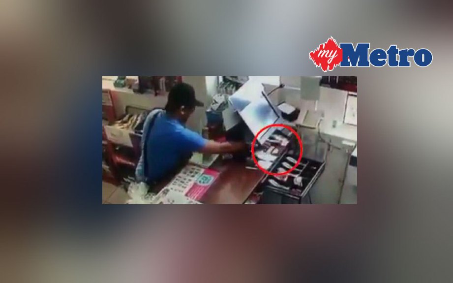 Rakaman CCTV menunjukkan seorang lelaki mengambil wang dari kaunter juruwang di stesen minyak di Taman Pasir Putih.