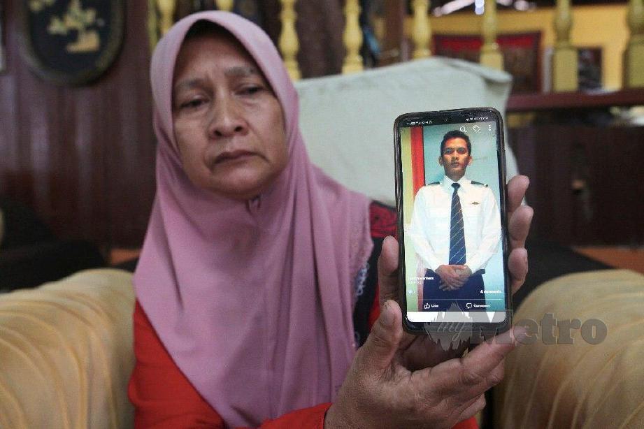 ZALEHA menunjukkan gambar anaknya, Ahmad Farid yang maut dipercayai dipukul di Kampung Bukit Gasing. FOTO Ghazali Kori
