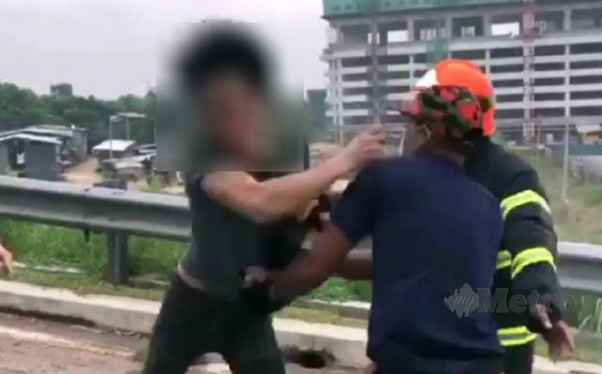 Petikan daripada video tular menunjukkan seorang lelaki menumbuk anggota bomba yang menghalangnya daripada menghampiri kereta terbakar. 