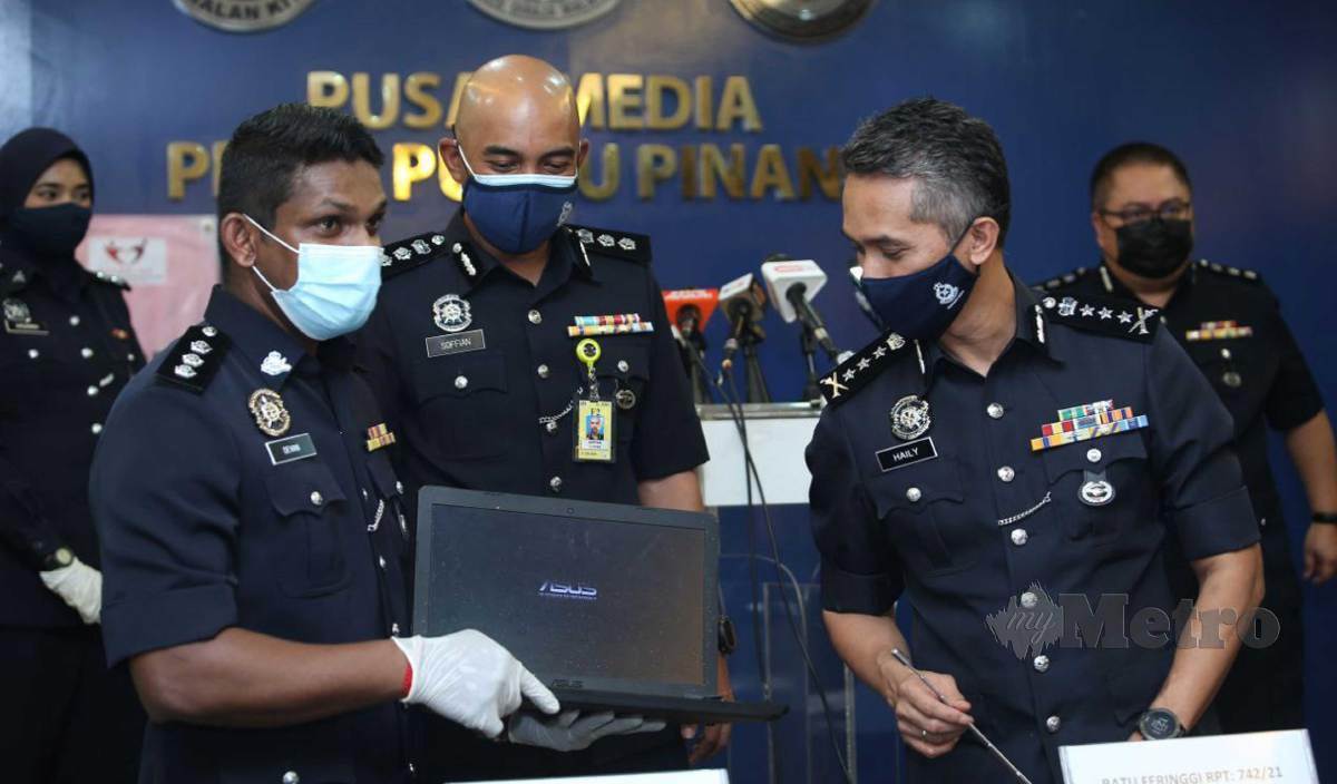 MOHD Shuhaily (kanan) meilhat barang kes berjaya di rampas dalam tangkapan ke atas sindiket pinjaman wang tidak wujud (PTW) melalui atas talian ketika sidang media di IPK Pulau Pinang. FOTO Mikail Ong