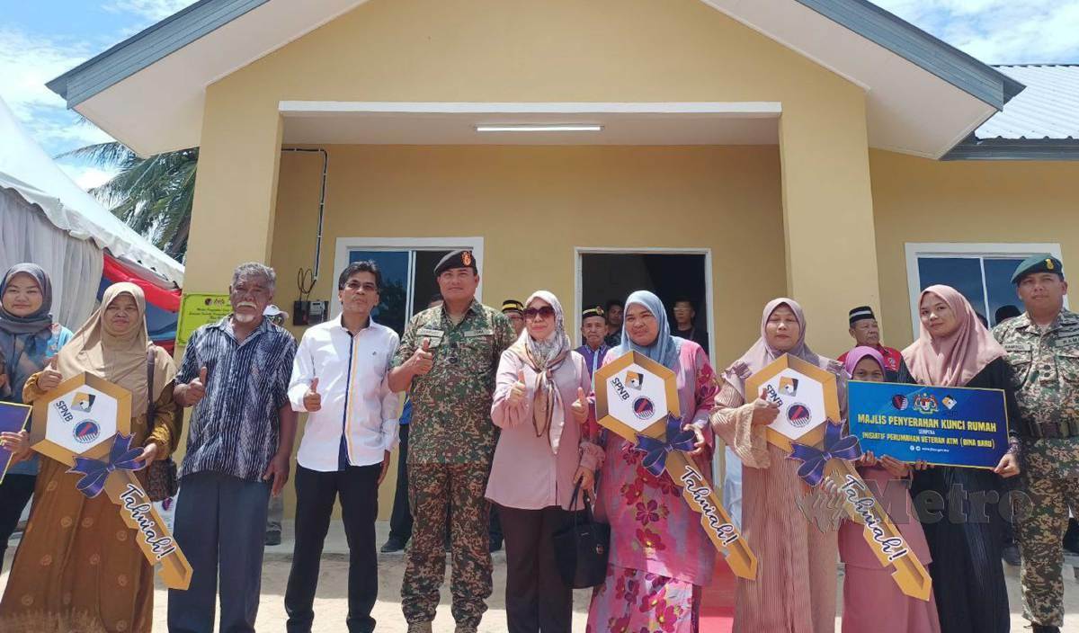 ZAMBERY Jeffery (tengah) bergambar bersama tiga penerima rumah baharu di bawah Inisiatif Perumahan Veteran ATM di Kampung Baru Nelayan. FOTO Siti Rohana Idris
