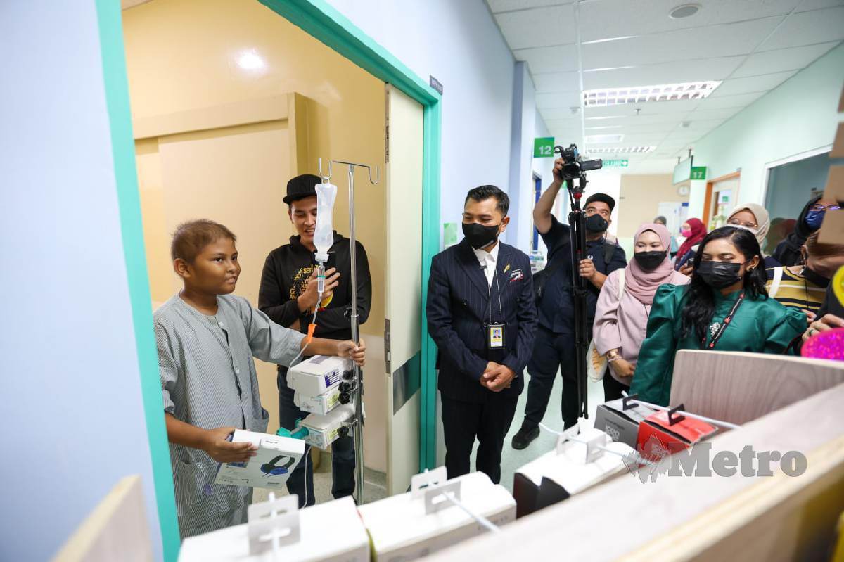 SEORANG pesakit kanak-kanak yang menghidap kanser gembira setelah mendapat hadiah pada Program Titipan Kasih Syawal Harian Metro Bersama Tune Protect. FOTO Aswadi Alias