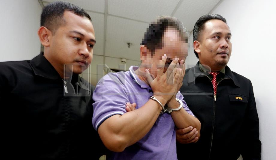 SUSPEK (tengah) dibawa pegawai SPRM untuk direman bagi membantu siasatan kes tuntutan palsu RM500,000 di Mahkamah Sesyen Kuala Terengganu, hari ini. FOTO Rozainah Zakaria.