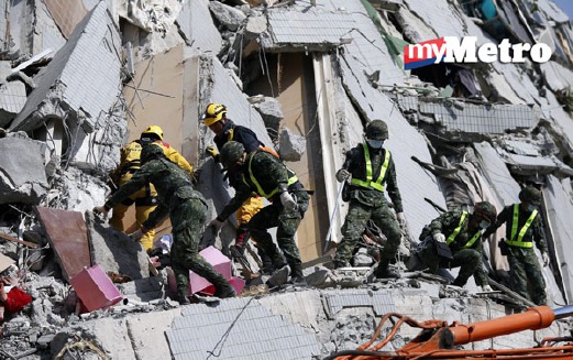 Pasukan penyelamat termasuk tentera Taiwan menggunakan kren dan gerudi untuk mengalihkan runtuhan besar bagi menyelamatkan mangsa yang terperangkap. - Foto EPA