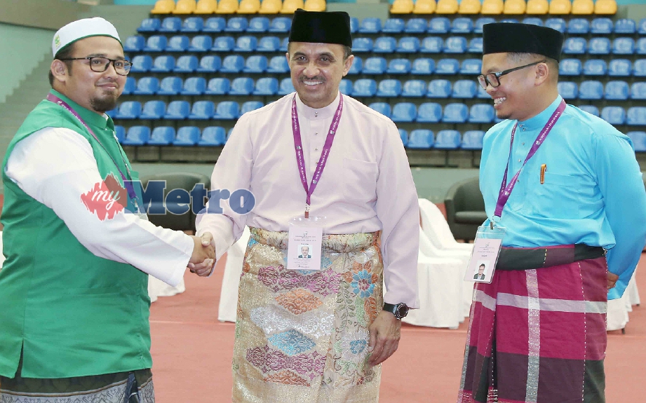 Zulhasnan (tengah) bersalam dengan Ubaid sambil diperhatikan oleh Nik Nazmi semasa proses penamaan calon pagi tadi. FOTO Mohd Yusni Ariffin 