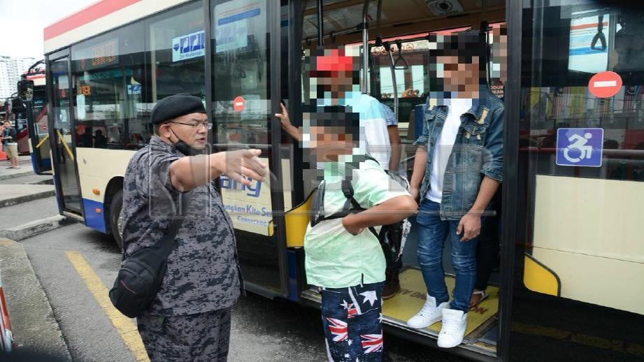 ANGGOTA Jabatan Imigresen Malaysia (JIM) Pulau Pinang mengarahkan warga asing menjalani pemeriksaan di stesen bas sementara Pengkalan Raja Uda, Butterworth, hari ini. FOTO Ihsan JIM
