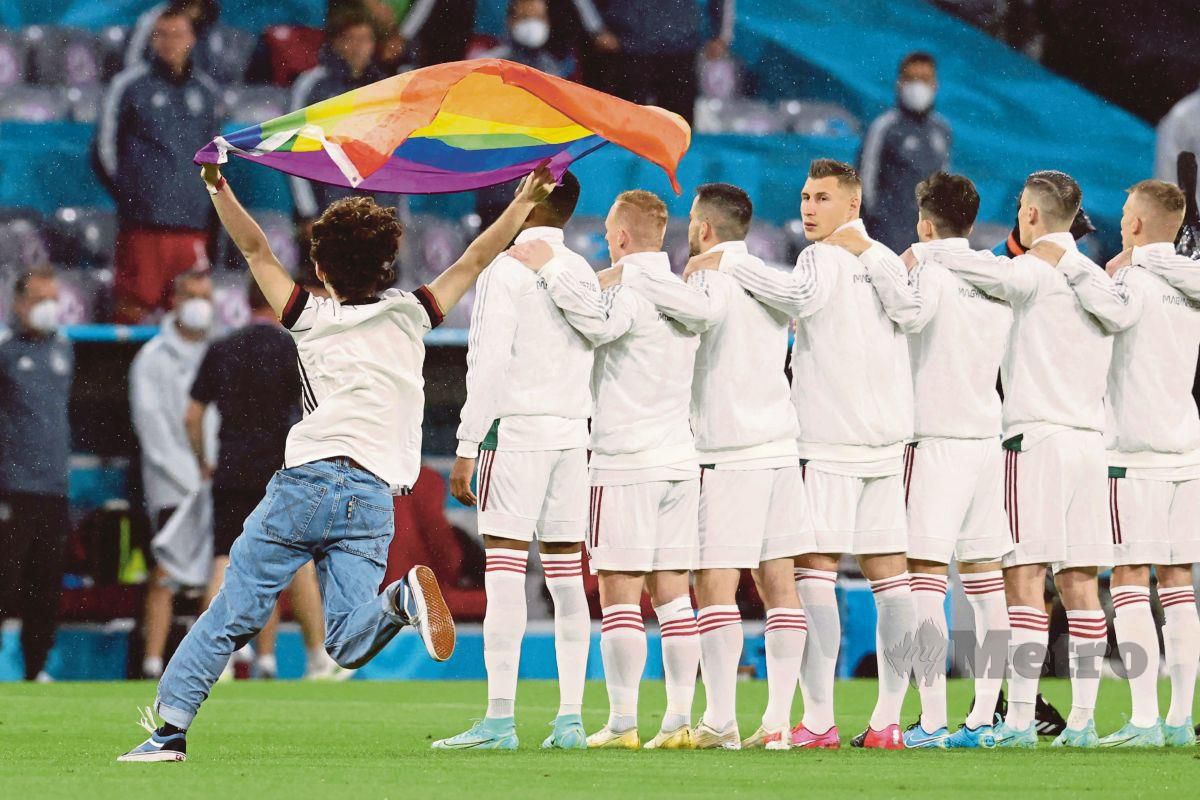 SEORANG penyokong mengibarkan bendera berwarna pelangi ketika lagu kebangsaan Hungary sedang dimainkan di Allianz Arena. FOTO AFP