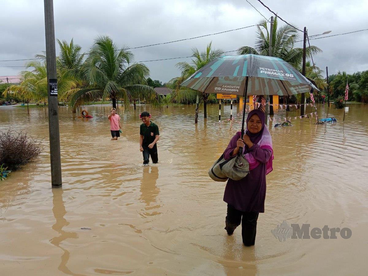 ZAKIAH meredah banjir di PPS Projek Penyusunan Semula Kampung (PPSK) Felcra Gunung Menerong. FOTO Nazdy Harun