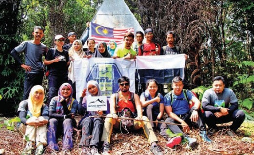 MAZLAN , 35, (duduk tengah) bersama rakan pendaki bergambar kenangan di puncak Gunung Berantai di Kampung Jara, Maran.