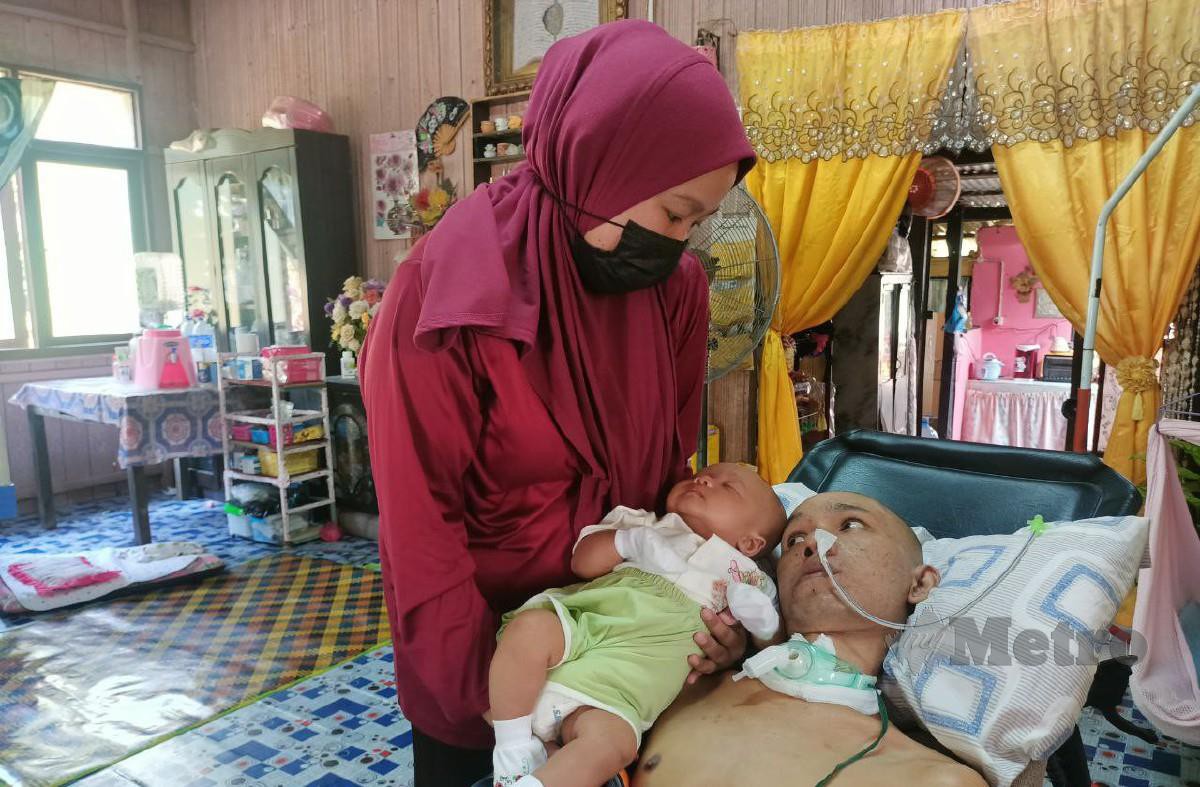 Siti Nor Shafika meletakkan bayi lelakinya di sisi suaminya, Mohamad Rosdi. FOTO SITI ROHANA IDRIS