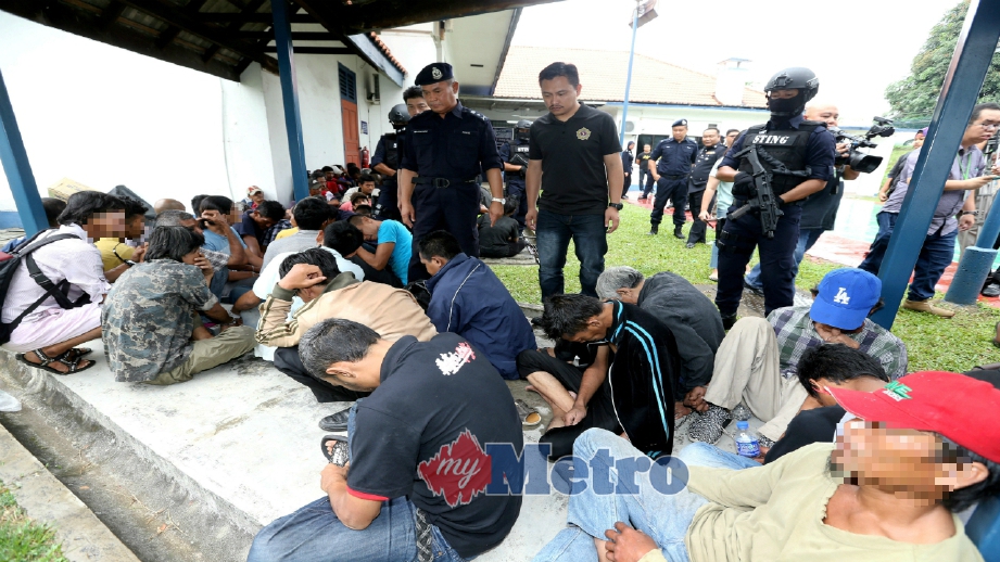 BAHAROM (berdiri, kiri) bertanya sesuatu kepada penagih yang ditahan dalam Ops Sarang di IPK Johor, hari ini. FOTO Zain Ahmed