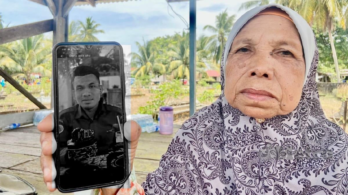 IBU mangsa, Noriah Awang menunjukkan gambar arwah anaknya, Lans Koperal Mohd Idris Abdul Samad yang meninggal dunia hari ini selepas dua hari dirawat akibat dipatuk ular tedung. FOTO Hazira Ahmad Zaidi.
