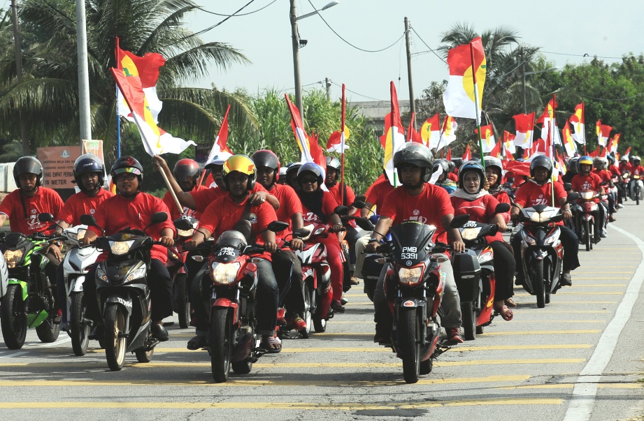 SEBAHAGIAN daripada 800 peserta konvoi bermotosikal membawa bendera UMNO ketika menyertai Larian Bendera sempena sambutan ulang tahun UMNO ke-71 di sempadan Parlimen Kepala Batas dan Tasek Gelugor dekat Kampung Paya, pada 5 Mei. FOTO Bernama