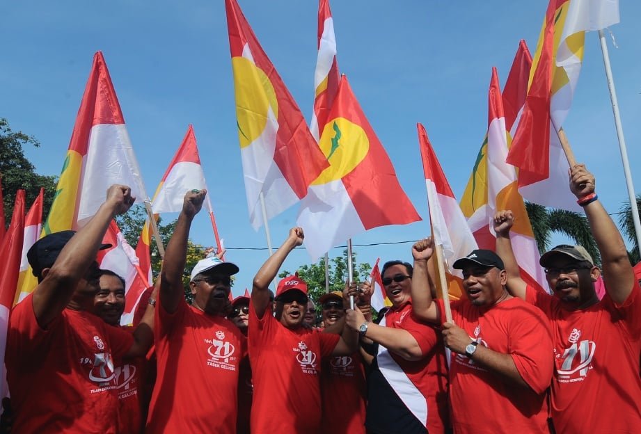 AHLI Parlimen Tasek Gelugor, Datuk Shabudin Yahaya (tiga, kiri), yang juga Ketua Penerangan Badan Perhubungan UMNO Negeri menerima bendera UMNO daripada Anggota Dewan Undangan Negeri (ADUN) Bertam Shariful Azhar Othman (tiga, kanan) pada Larian Bendera sempena sambutan ulang tahun UMNO ke-71, di sempadan Parlimen Kepala Batas dan Tasek Gelugor dekat Kampung Paya. FOTO Bernama