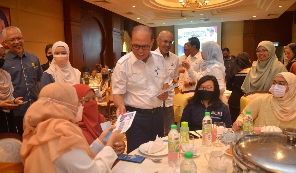 WAN Rosdy menyerahkan sumbangan kepada pelajar kelahiran Pahang di Majlis Penyampaian Bantuan Prihatin Pahang 2022 di Dewan Bankuasi, Canselori UMS, semalam. FOTO Mohd Adam Arinin