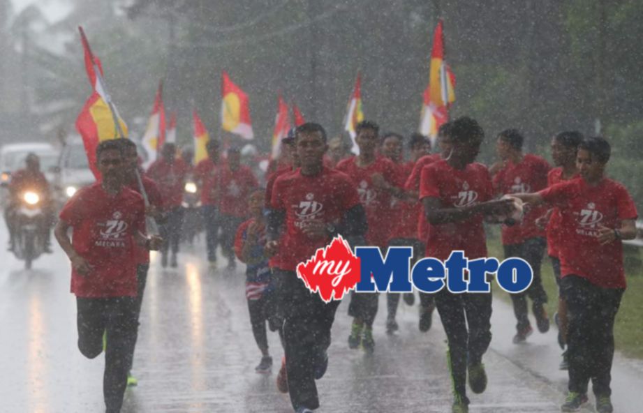 PESERTA meneruskan larian walaupun keadaan hujan dari Sungai Rambai ke Sri Bendahara ketika Larian Jelajah UMNO sempena sambutan ulang tahun UMNO ke 71. FOTO Syarafiq Abd Samad 