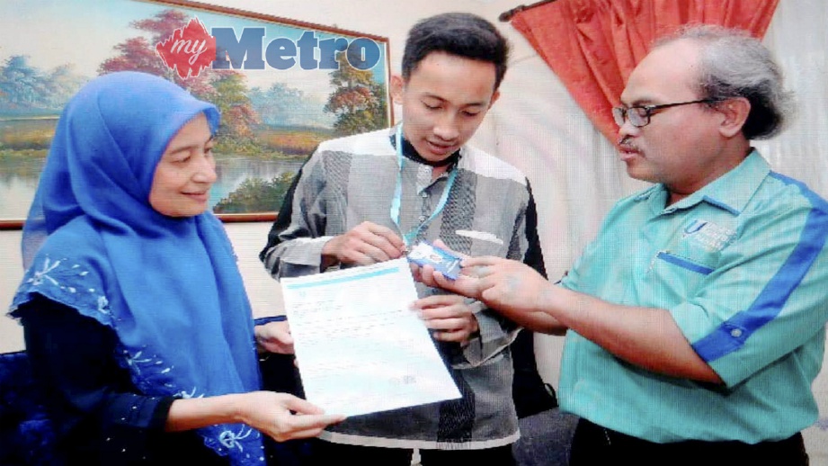 MUHAMAD (kanan) menyerahkan tag nama kepada Ahmad Afizfaiz (tengah) sambil diperhatikan Dr Ajura Abdul Jalil (kiri) di rumahnya di Bandar Baru Bangi, Selangor, hari ini. FOTO Ihsan UMP