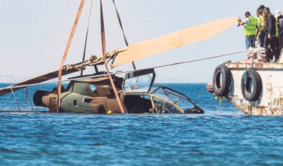 PEKERJA menurunkan helikopter tempur AH-1 Cobra di perairan Aqaba di Laut Merah. 