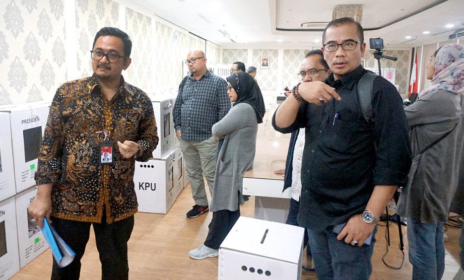 PEGAWAI KPU, Hasyim Asy'ari (kanan); pegawai Bawaslu, Ratna Dewi Pettalolo (tengah) dan pegawai Jawatankuasa Pilihan Raya Luar Negara (PPLN) Yusron Ambary (kiri) memeriksa gudang yang menempatkan kertas undi untuk pengundi negara itu di Kedutaan Indonesia di Kuala Lumpur.
