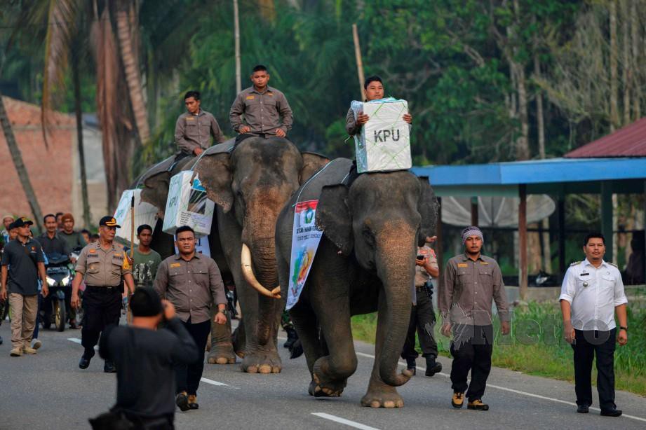 PETUGAS undi Indonesia membawa peti undi menggunakan gajah. FOTO/AFP