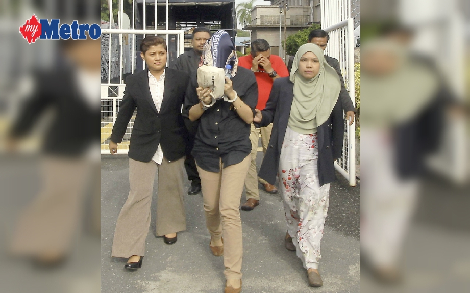 Anggota SPRM mengiringi Norfadilla (depan tengah) bersama Mohd Safry (baju merah) sebelum dihadapkan ke Mahkamah Seksyen, Kangar. FOTO Azhar Ramli 